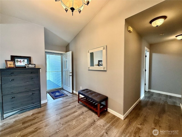 entryway featuring lofted ceiling, baseboards, and wood finished floors