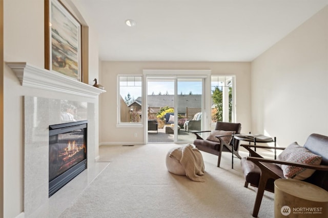 living area with a premium fireplace, carpet flooring, and baseboards