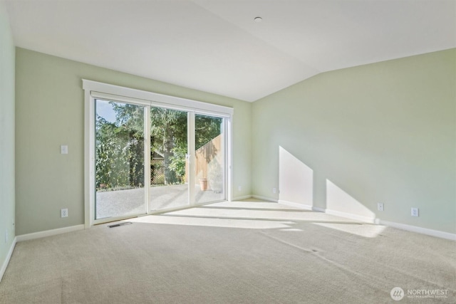 carpeted empty room with lofted ceiling and baseboards