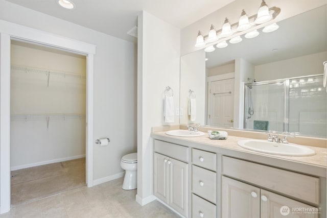 full bath with a sink, a shower stall, toilet, and double vanity