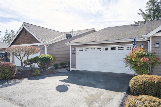 view of front of property with driveway, a shingled roof, and an attached garage