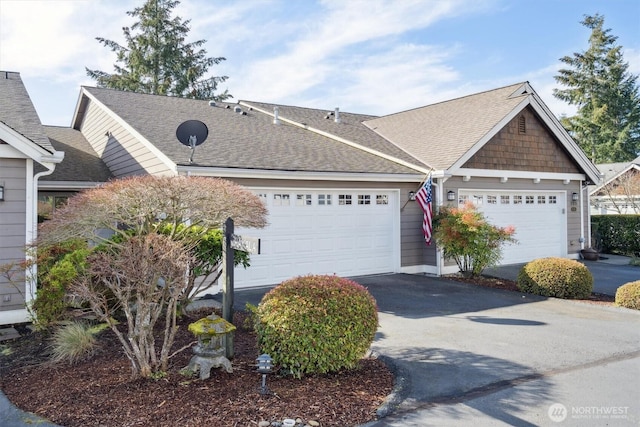 view of front of home with roof with shingles, driveway, and an attached garage