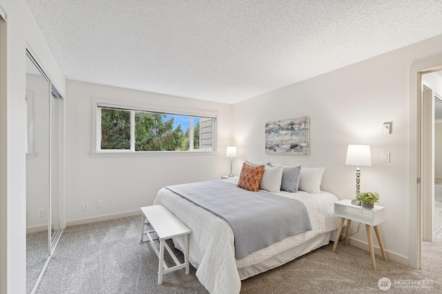 bedroom featuring carpet, a textured ceiling, and baseboards