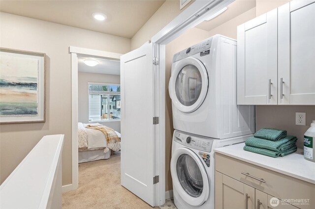 laundry area featuring light carpet, laundry area, and stacked washer / dryer