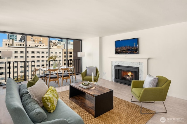 living area featuring a fireplace, wood finished floors, and floor to ceiling windows