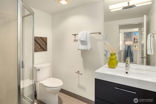 bathroom featuring wood finished floors, a stall shower, vanity, and toilet