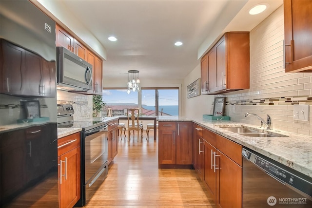 kitchen with dishwashing machine, electric range, a sink, light wood-style floors, and brown cabinetry