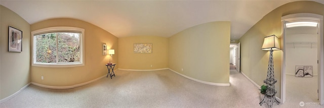 entryway with vaulted ceiling, carpet, and baseboards