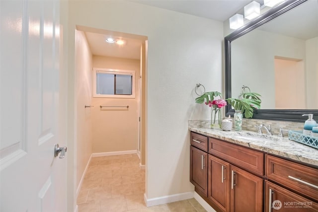 bathroom featuring tasteful backsplash, baseboards, and vanity