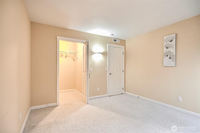 carpeted empty room with visible vents and baseboards