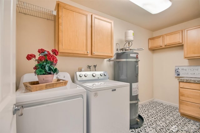 laundry area with cabinet space, water heater, baseboards, and washing machine and clothes dryer