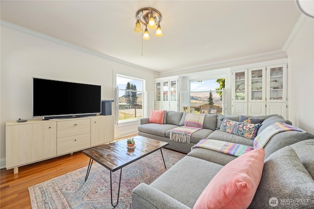 living room with light wood-style floors and ornamental molding