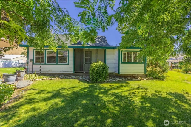 rear view of house featuring a lawn