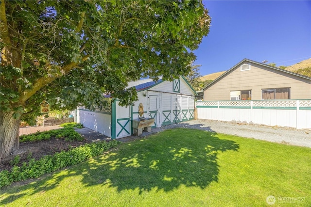 view of yard featuring an outbuilding, fence, and a storage unit