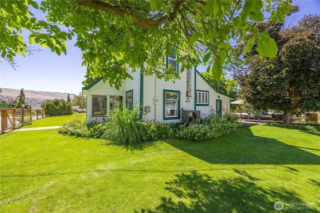 view of front of home featuring a front lawn, fence, and a mountain view