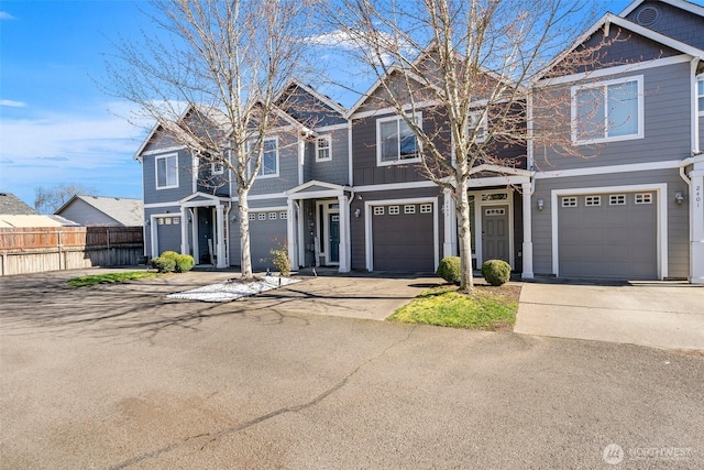 view of front of home featuring driveway, an attached garage, and fence