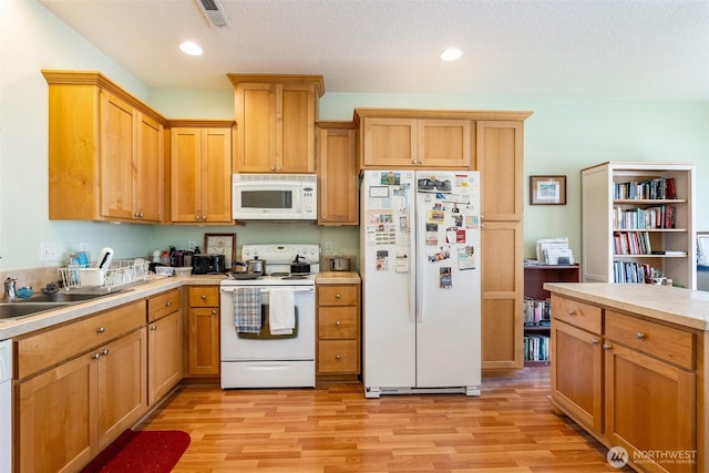 kitchen with recessed lighting, white appliances, visible vents, light countertops, and light wood finished floors