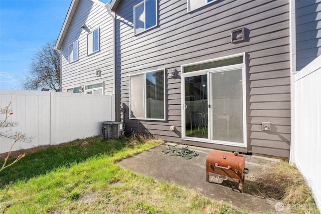 rear view of property featuring central AC unit and fence