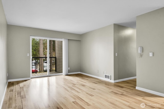 unfurnished room featuring visible vents, baseboards, and wood finished floors