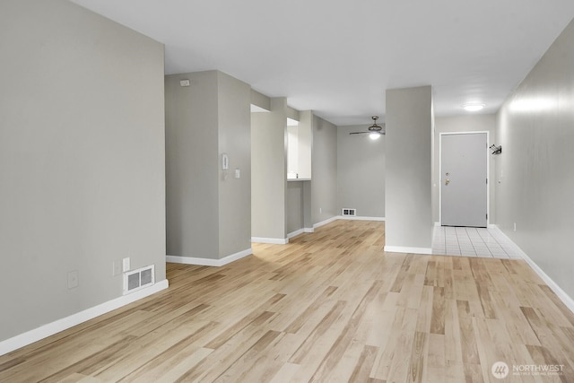 unfurnished room with ceiling fan, baseboards, visible vents, and light wood-style floors