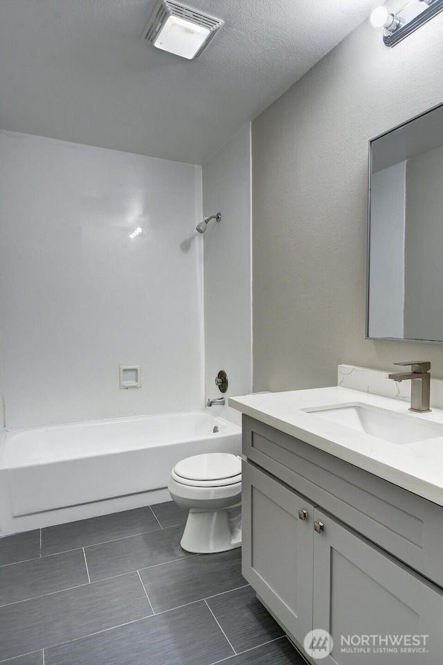 full bathroom featuring visible vents, toilet, vanity, a textured ceiling, and  shower combination