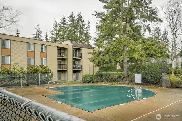 view of swimming pool featuring fence