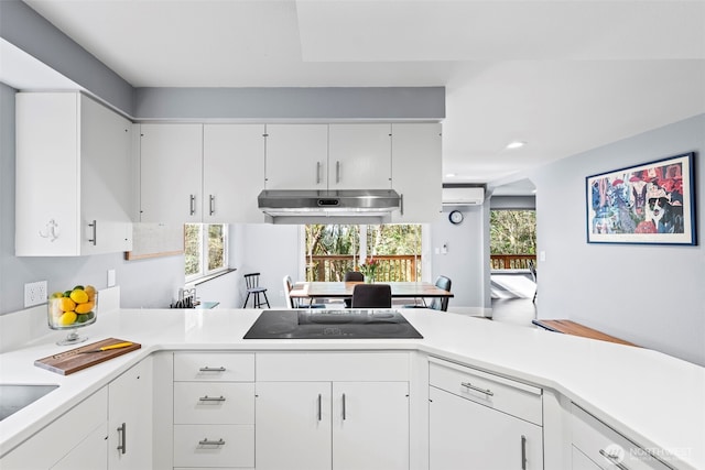 kitchen with under cabinet range hood, white cabinetry, black electric stovetop, and light countertops