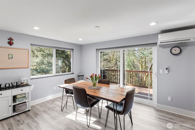 dining area featuring plenty of natural light, a wall unit AC, and baseboards