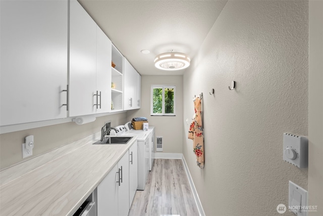 kitchen featuring baseboards, white cabinets, light wood-style flooring, separate washer and dryer, and open shelves