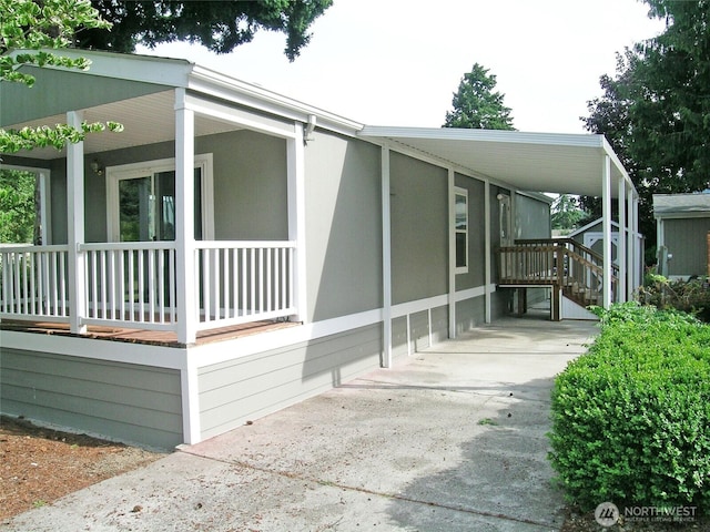 view of front of property with an attached carport, concrete driveway, and covered porch