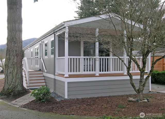 view of property exterior with covered porch and stairway