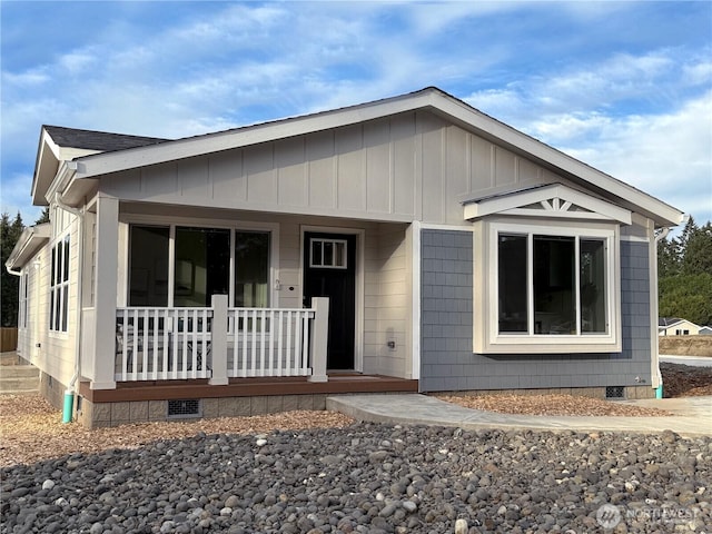 view of front facade with crawl space, covered porch, and roof with shingles