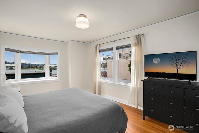 bedroom featuring light wood-style flooring and baseboards