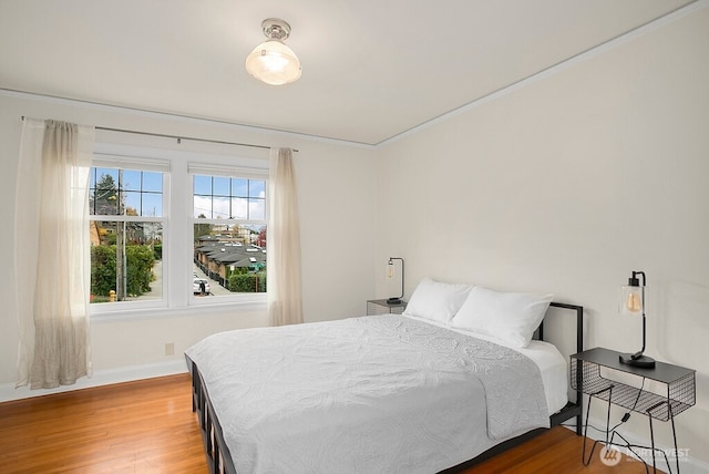 bedroom with wood finished floors and baseboards