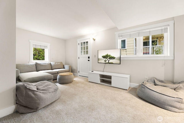 carpeted living room featuring baseboards