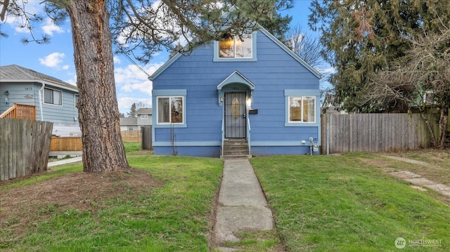 bungalow-style home featuring fence and a front lawn