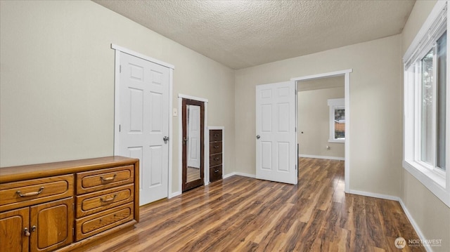 bedroom featuring a textured ceiling, baseboards, and dark wood-style flooring