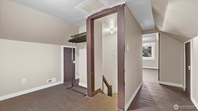 bonus room featuring lofted ceiling, baseboards, visible vents, and wood finished floors