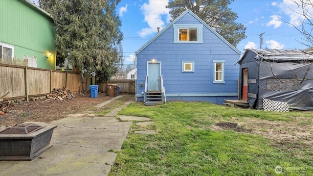 back of house with entry steps, fence, and a lawn