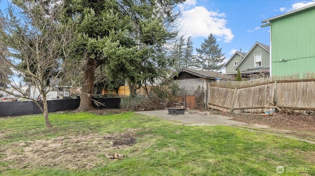 view of yard featuring a fenced backyard and a fire pit