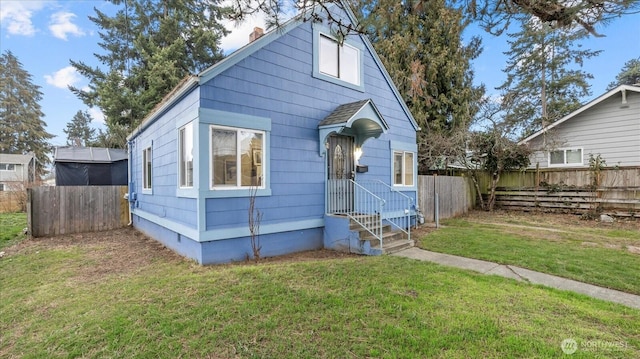 view of front of property featuring crawl space, fence, and a front lawn