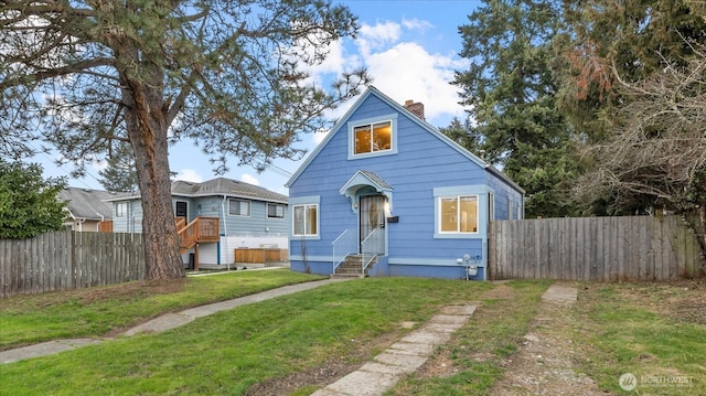 bungalow-style home with a front lawn, a chimney, and fence