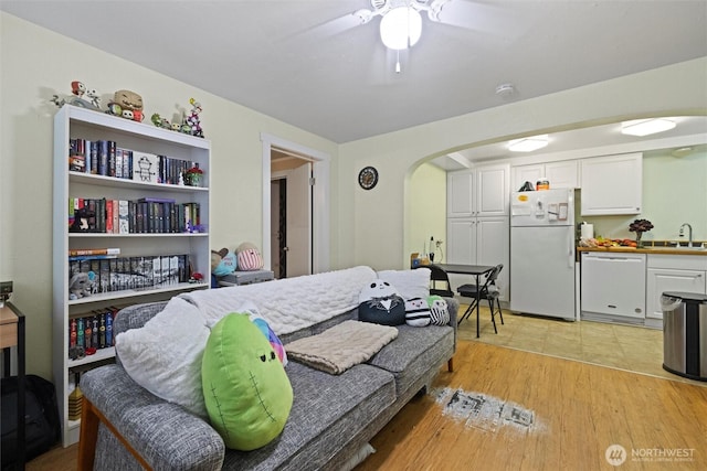 bedroom with arched walkways, a sink, a ceiling fan, light wood-type flooring, and freestanding refrigerator