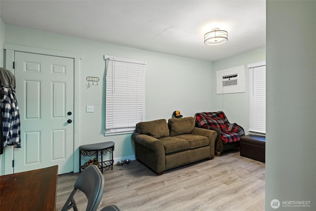 living area with wood finished floors and a wall mounted AC