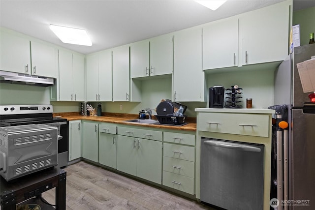 kitchen featuring light wood-style floors, appliances with stainless steel finishes, a sink, wood counters, and under cabinet range hood