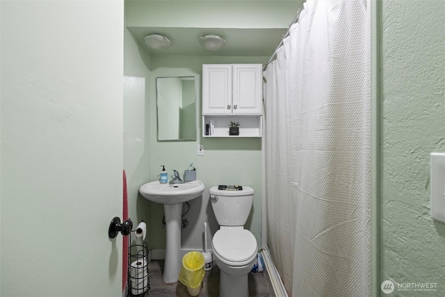 bathroom featuring a sink, curtained shower, wood finished floors, and toilet