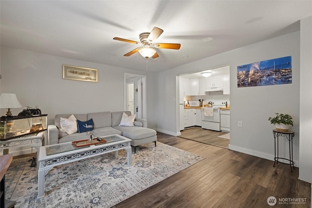 living room featuring dark wood-style flooring, ceiling fan, and baseboards