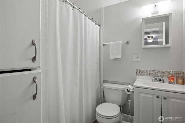 full bathroom featuring toilet, vanity, and decorative backsplash