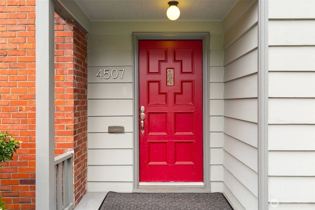 entrance to property featuring brick siding