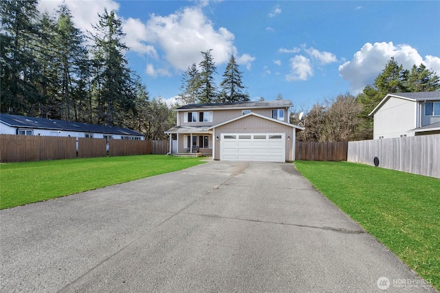 traditional-style house featuring a garage, driveway, a front yard, and fence